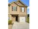 Charming two-story townhome with beige siding, brick accents, and a single-car garage at 6001 Oak Bend Ct, Riverdale, GA 30296