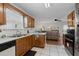 Bright and airy kitchen with a sink, black dishwasher, and wooden cabinetry at 6606 Coventry Pt, Austell, GA 30168