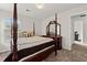 Bedroom with dark four-poster bed, carpet, and windows for natural light at 6606 Coventry Pt, Austell, GA 30168