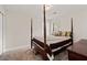 Cozy main bedroom with four-poster bed, carpet, and natural light at 6606 Coventry Pt, Austell, GA 30168