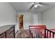 Bright bedroom featuring a crib, dark dresser, and overhead fan lighting at 2090 Marbut Ln, Lithonia, GA 30058