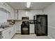 Cozy kitchen featuring white cabinets, a black refrigerator, and stainless steel sink at 2090 Marbut Ln, Lithonia, GA 30058