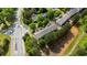 Aerial view of townhomes surrounded by trees, located near a road and tranquil pond at 2625 Cedar Dr, Lawrenceville, GA 30043