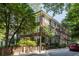 Brick building is situated on a tree-lined street with lush landscaping and a red car parked nearby at 301 10Th Ne St # 12, Atlanta, GA 30309