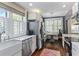 Sunlit kitchen boasts white cabinetry, stainless steel appliances, a cozy breakfast nook, and dark hardwood flooring at 301 10Th Ne St # 12, Atlanta, GA 30309