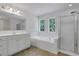 Bathroom featuring a soaking tub, walk-in shower, vanity, and bright windows at 3208 Juniper Nw Dr, Kennesaw, GA 30144
