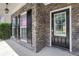 Inviting front porch with stone accents, black shutters, and a glass-paneled front door at 3208 Juniper Nw Dr, Kennesaw, GA 30144