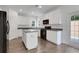 Well-lit kitchen with white cabinetry, black appliances, and a center island at 3208 Juniper Nw Dr, Kennesaw, GA 30144