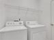 Functional laundry room with a modern washer and dryer set, with overhead storage at 3208 Juniper Nw Dr, Kennesaw, GA 30144