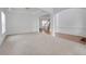 Open living room with neutral carpet, staircase access, and white walls at 3208 Juniper Nw Dr, Kennesaw, GA 30144