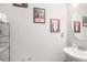 Half-bathroom with pink wall art and a round mirror above a pedestal sink at 7762 Fawn Cir, Covington, GA 30014