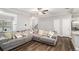 Open-concept living room with hardwood floors, a large sectional sofa, and ample natural light at 7762 Fawn Cir, Covington, GA 30014