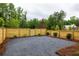 Gravel backyard surrounded by a wooden fence and lush greenery at 11542 Serenbe Ln, Chattahoochee Hills, GA 30268