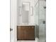 Bathroom boasting a wood vanity with marble countertop, rectangular mirror, and glass-enclosed shower at 11542 Serenbe Ln, Chattahoochee Hills, GA 30268