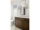 Bathroom showcasing a dark wood vanity, large mirror, and a window providing natural light at 11542 Serenbe Ln, Chattahoochee Hills, GA 30268