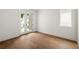Bright bedroom with hardwood floors, white walls, and access to the outdoors through glass panel doors at 11542 Serenbe Ln, Chattahoochee Hills, GA 30268