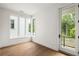 Bright room features hardwood floors, large windows, and a glass door to a small balcony at 11542 Serenbe Ln, Chattahoochee Hills, GA 30268