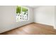 Spacious bedroom with hardwood floors and a large window providing natural light and neighborhood views at 11542 Serenbe Ln, Chattahoochee Hills, GA 30268