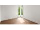 Empty bedroom featuring hardwood floors, white walls, and a window showcasing natural light at 11542 Serenbe Ln, Chattahoochee Hills, GA 30268