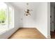 Modern dining room with stylish light fixture, hardwood floors, and bright natural light at 11542 Serenbe Ln, Chattahoochee Hills, GA 30268