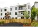 Modern townhome exterior with sleek lines, balconies, and a fenced yard at 11542 Serenbe Ln, Chattahoochee Hills, GA 30268