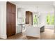 Bright kitchen features a marble waterfall island, stainless steel appliances, and hardwood floors at 11542 Serenbe Ln, Chattahoochee Hills, GA 30268