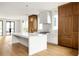 Spacious kitchen boasts custom cabinetry, a large island with seating, and hardwood flooring at 11542 Serenbe Ln, Chattahoochee Hills, GA 30268
