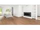 Open-concept living space featuring hardwood floors, a modern fireplace, and built-in shelving at 11542 Serenbe Ln, Chattahoochee Hills, GA 30268