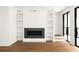 Cozy living room with a modern fireplace, built-in shelves, and access to the backyard at 11542 Serenbe Ln, Chattahoochee Hills, GA 30268