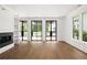 Spacious living room with hardwood floors, a modern fireplace, and lots of natural light from large windows at 11542 Serenbe Ln, Chattahoochee Hills, GA 30268