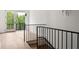 Staircase with a black iron railing and a view of the outdoors at 11542 Serenbe Ln, Chattahoochee Hills, GA 30268