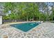 Sparkling in-ground pool surrounded by a stone patio and lush greenery at 4439 Luther Ward Rd, Powder Springs, GA 30127
