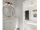Stylish bathroom with a round mirror above a white vanity, and a view into the bedroom at 2335 Mason Dr # D27, Atlanta, GA 30316