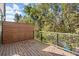 View of the wooden deck with a privacy screen, metal railing, and mature trees in the background at 2335 Mason Dr # D27, Atlanta, GA 30316