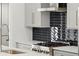 Close-up of kitchen featuring stainless steel cooktop and modern black tiled backsplash at 2335 Mason Dr # D27, Atlanta, GA 30316