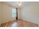 A bright bedroom with a ceiling fan and natural light from a large window with hardwood floors at 303 Cimarron Way, Lawrenceville, GA 30044