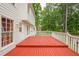 Red painted deck wraps around side of the house and leads to the fenced-in backyard at 303 Cimarron Way, Lawrenceville, GA 30044