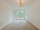 Spacious dining room with bay window, chandelier, and carpet flooring at 303 Cimarron Way, Lawrenceville, GA 30044