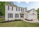 Traditional two-story home featuring white siding, dark shutters, and an inviting front yard landscape at 303 Cimarron Way, Lawrenceville, GA 30044