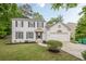 Charming white two-story home with dark shutters and a well-manicured front lawn and attached two car garage at 303 Cimarron Way, Lawrenceville, GA 30044
