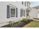 Side view of a white house with dark shutters, a well-maintained garden, and a welcoming entrance at 303 Cimarron Way, Lawrenceville, GA 30044