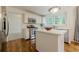 Bright kitchen featuring stainless steel appliances, white cabinets, hardwood floors and an island at 303 Cimarron Way, Lawrenceville, GA 30044
