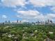 Aerial view of the city skyline surrounded by lush green trees and single Gathering homes at 686 Amsterdam Ne Ave, Atlanta, GA 30306