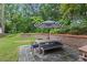 A patio set for six with a large umbrella sits on a stone patio in the backyard at 686 Amsterdam Ne Ave, Atlanta, GA 30306