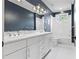 Modern bathroom with blue accent wall featuring double sinks, white cabinets, and tiled floor and tub at 686 Amsterdam Ne Ave, Atlanta, GA 30306