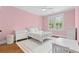 Bright bedroom with pink walls featuring a ceiling fan, hardwood floors, shutters, and furniture at 686 Amsterdam Ne Ave, Atlanta, GA 30306