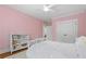 Bright bedroom with pink walls featuring a ceiling fan, closet, bookshelf, and hardwood floors at 686 Amsterdam Ne Ave, Atlanta, GA 30306
