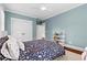Bright bedroom with light-blue walls featuring a ceiling fan, closet, bookshelf, and hardwood floors at 686 Amsterdam Ne Ave, Atlanta, GA 30306