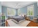 A secondary bedroom featuring blue walls, plantation shutters, wood floors, and neutral decor at 686 Amsterdam Ne Ave, Atlanta, GA 30306