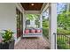 Relaxing front porch featuring a swing, brick flooring, and views of the landscaped yard at 686 Amsterdam Ne Ave, Atlanta, GA 30306